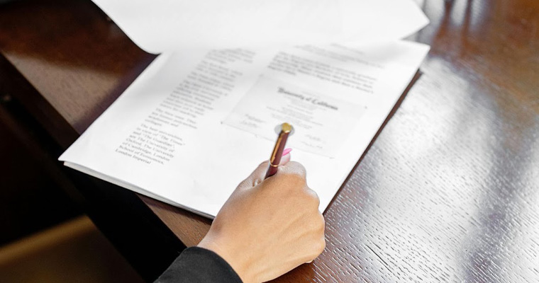 A person is signing a document in a legal office.